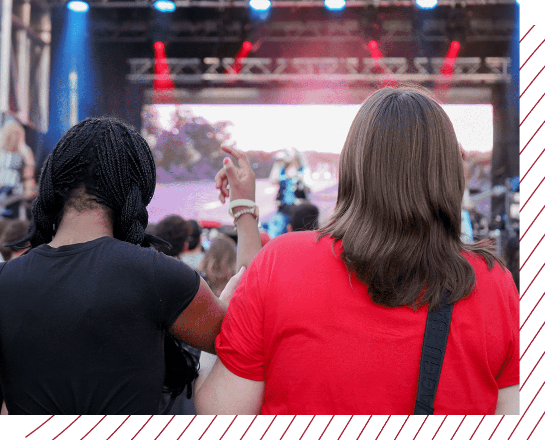 close up photo from behind of two students enjoying a concert